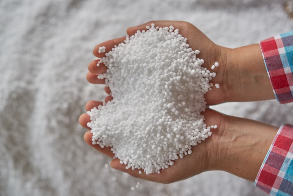 Man holding handful of Prilled Urea ice melt