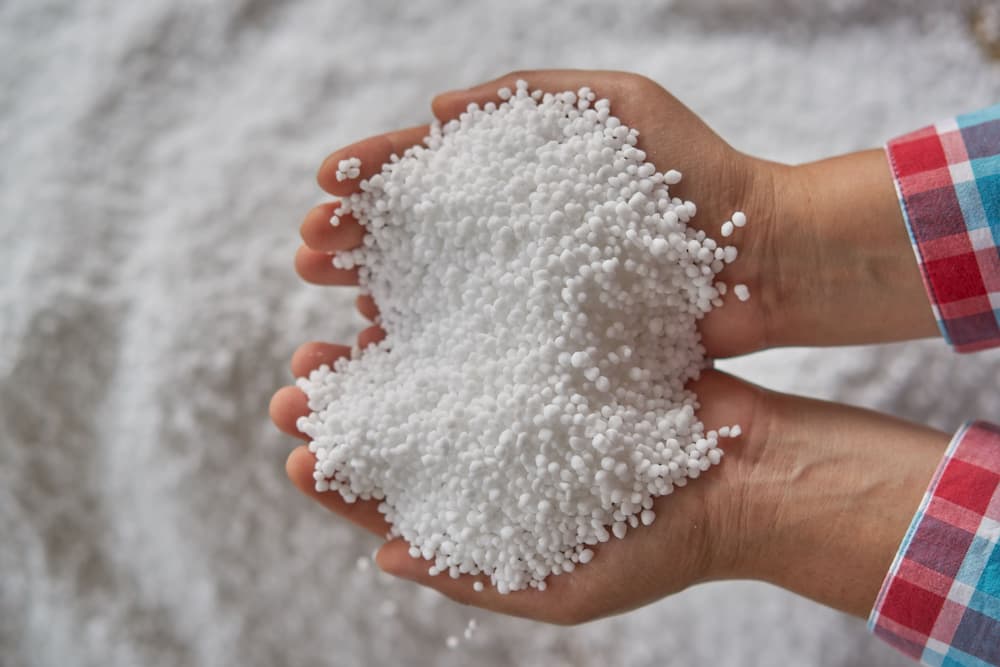 Man holding handful of prilled urea