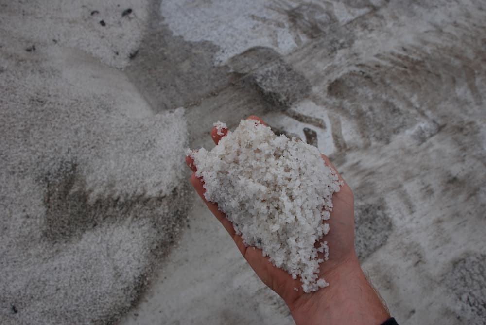 Man holding a handful of White De-Icing salt